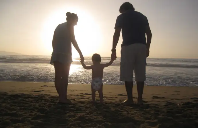 Imagem de uma família junto à praia