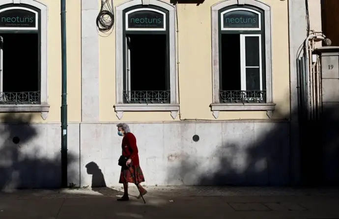 Idosa ao fundo a atravessar a rua